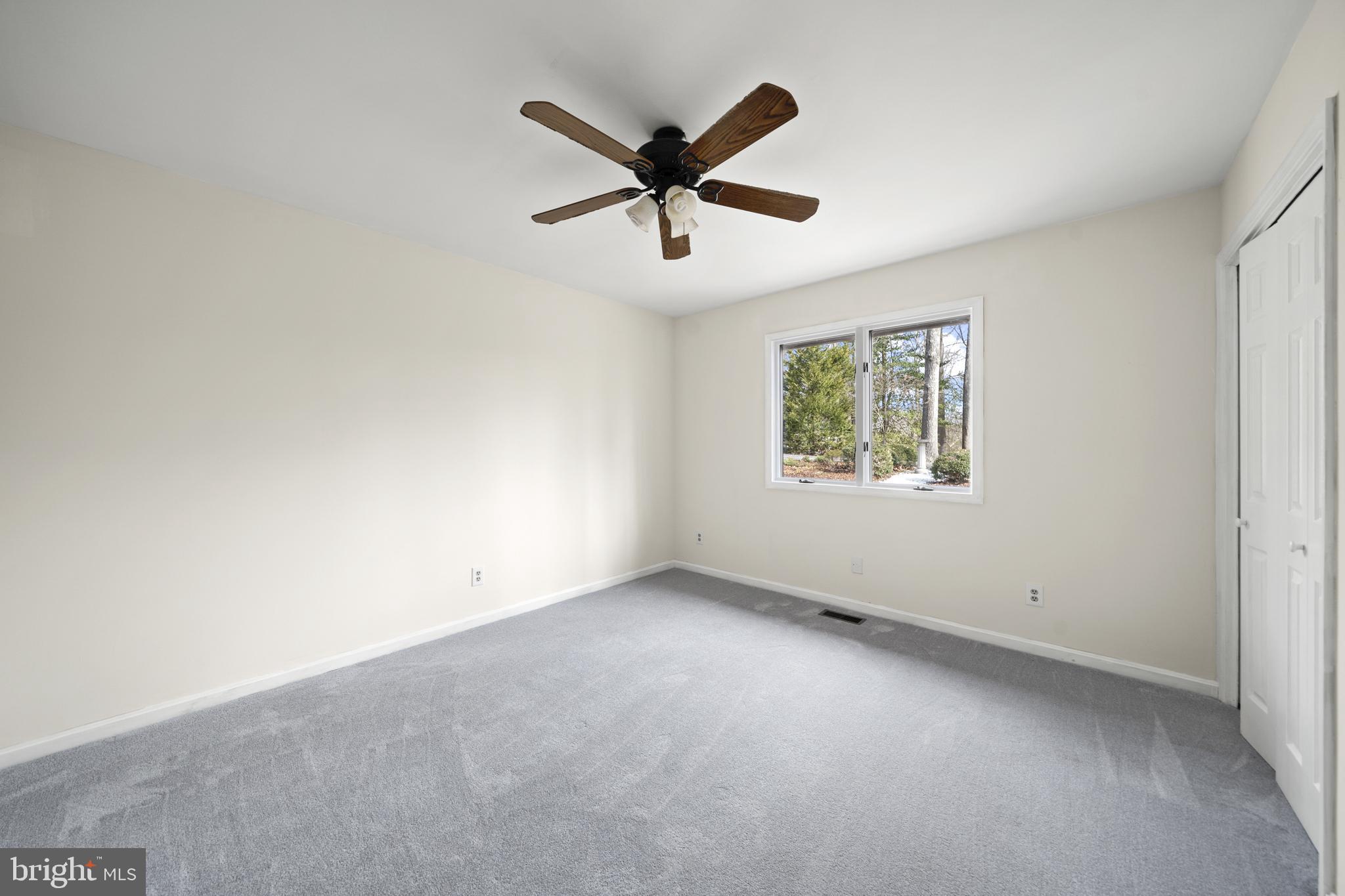 6251 Stephen Reid Road Huntingtown, MD 20639 - Photo 21 of 46 an empty room with ceiling fan and windows