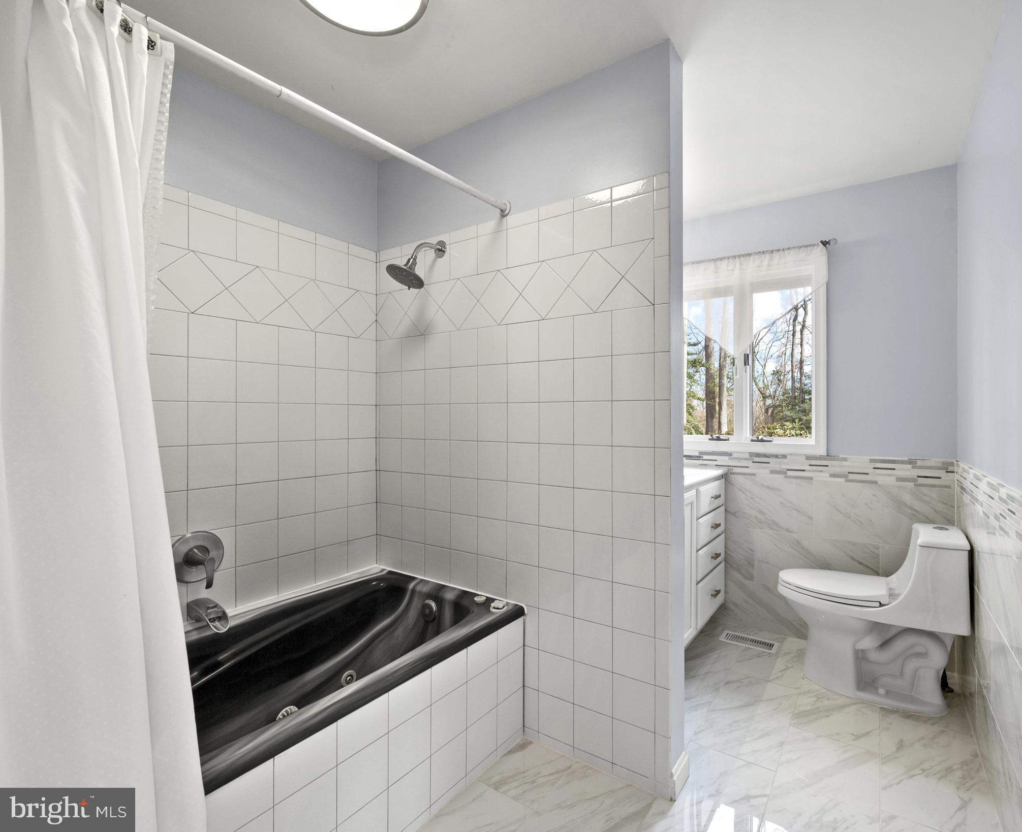 6251 Stephen Reid Road Huntingtown, MD 20639 - Photo 22 of 46 a bathroom with a sink a toilet a window and shower