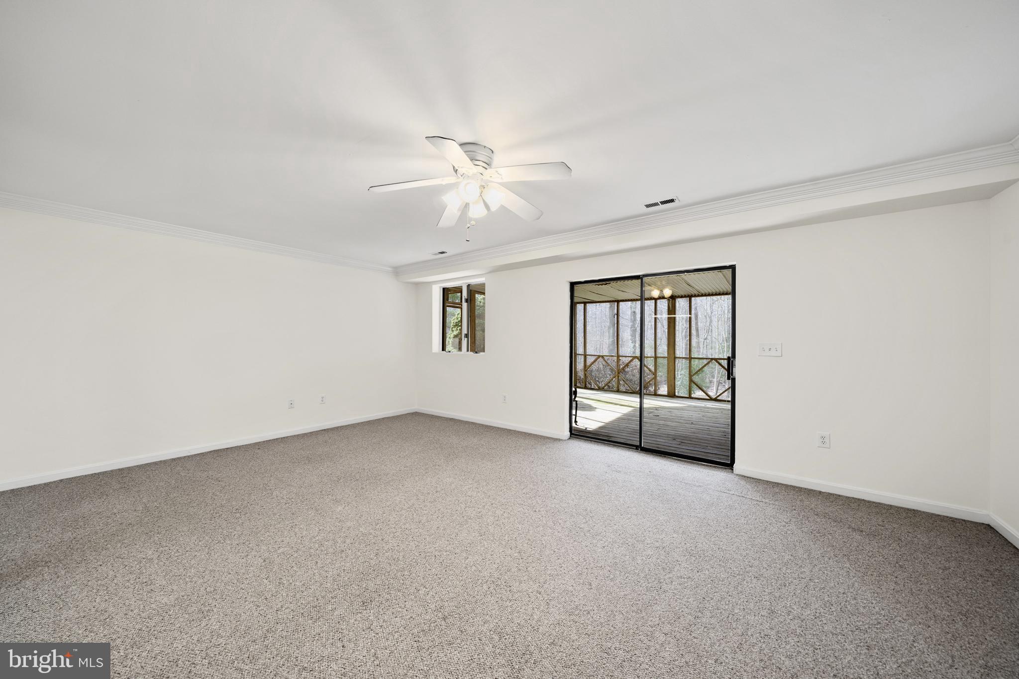 6251 Stephen Reid Road Huntingtown, MD 20639 - Photo 25 of 46 an empty room with chandelier fan and windows