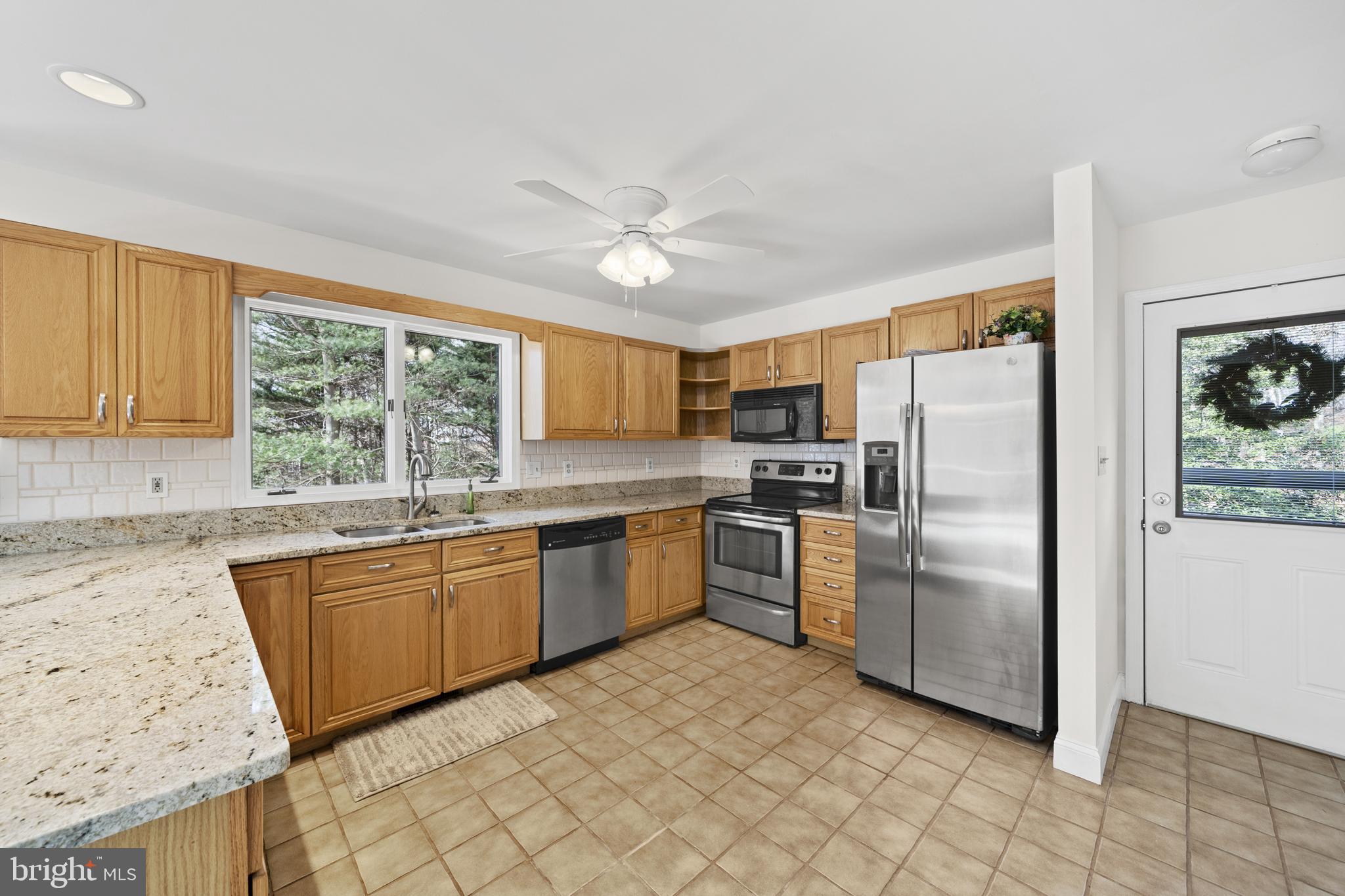 6251 Stephen Reid Road Huntingtown, MD 20639 - Photo 28 of 46 a kitchen with granite countertop stainless steel appliances a refrigerator stove top oven and sink