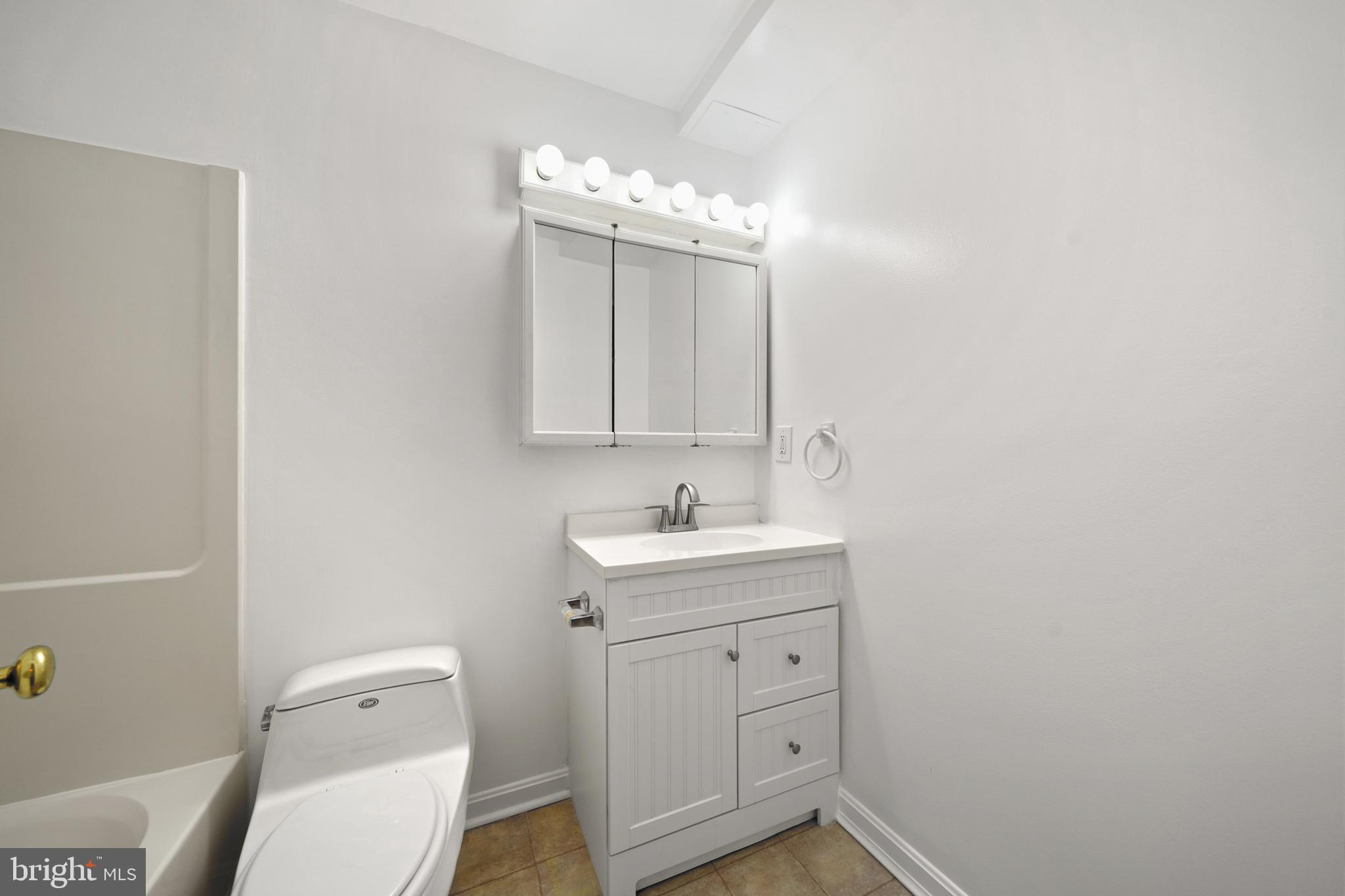 6251 Stephen Reid Road Huntingtown, MD 20639 - Photo 33 of 46 a bathroom with a toilet a sink a mirror a vanity and window