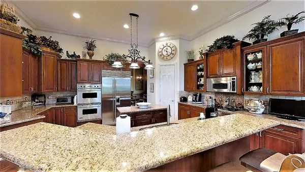 a kitchen with granite countertop a sink stove and refrigerator