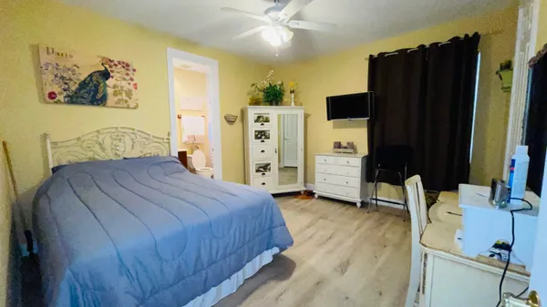 a bedroom with a bed and a mirror on the dresser