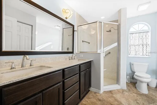 a bathroom with a double vanity sink toilet mirror and bathtub