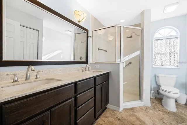 a bathroom with a double vanity sink toilet mirror and bathtub