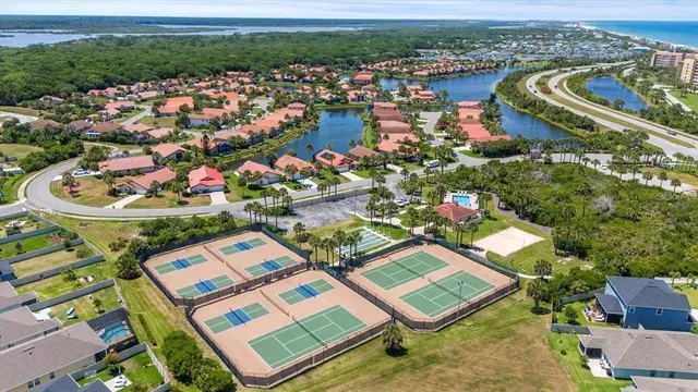 an aerial view of a city with lots of residential buildings ocean and mountain view in back