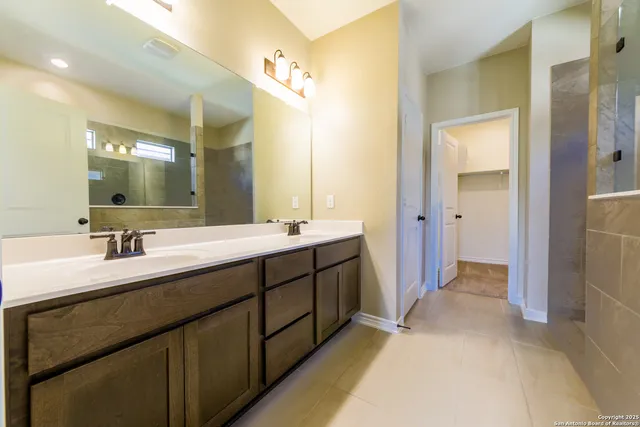 a bathroom with a double vanity sink mirror and shower