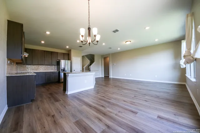 a large kitchen with stainless steel appliances granite countertop a large counter top and wooden floors