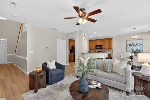 a living room with furniture and a view of kitchen
