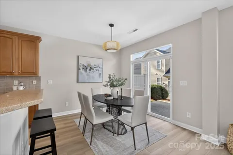 a dining room with furniture a chandelier and wooden floor