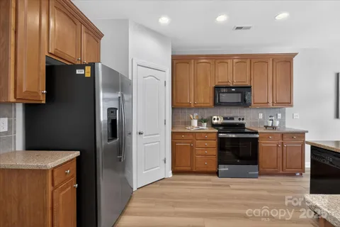 a kitchen with stainless steel appliances granite countertop a refrigerator stove and sink