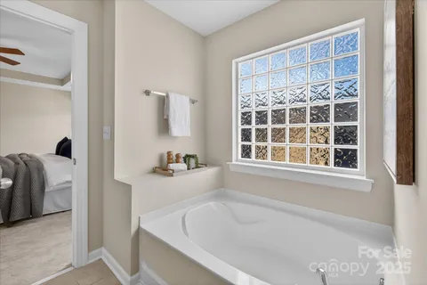 a bathroom with bathtub and windows