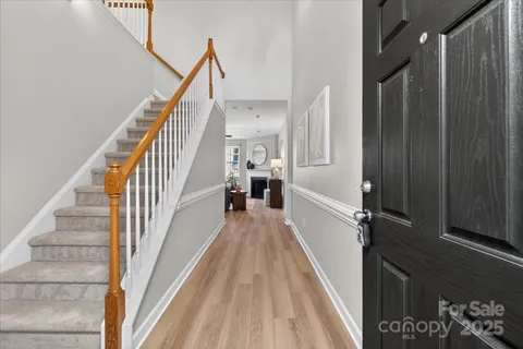 a view of a hallway with wooden floor and staircase
