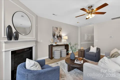 a living room with furniture a fireplace and a large mirror