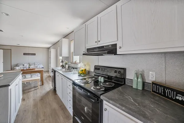 a kitchen with granite countertop a stove sink and cabinets