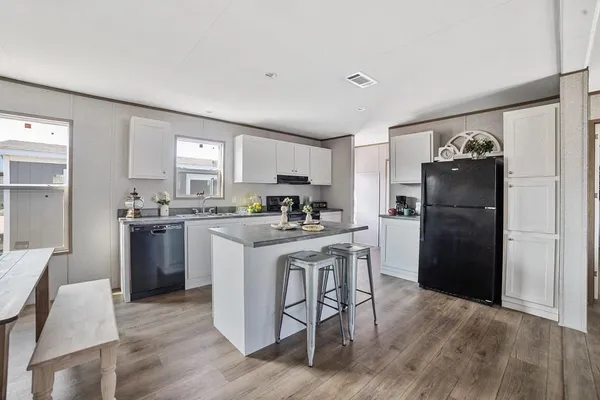 a kitchen with a refrigerator a sink dishwasher with a dining table and chairs