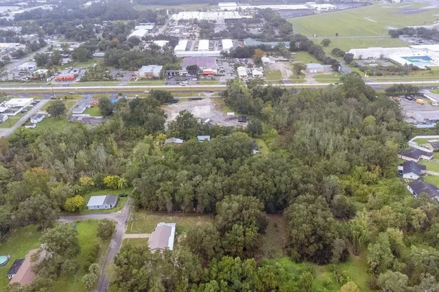 an aerial view of residential houses with outdoor space and trees
