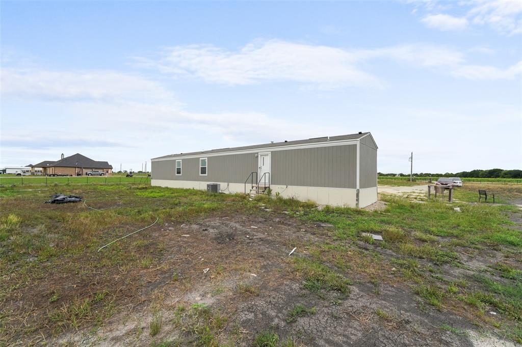 0 Ewing Road Ferris, TX 75125 - Photo 22 of 29 Single-story structure featuring a light gray siding and a contrasting darker gray roof
