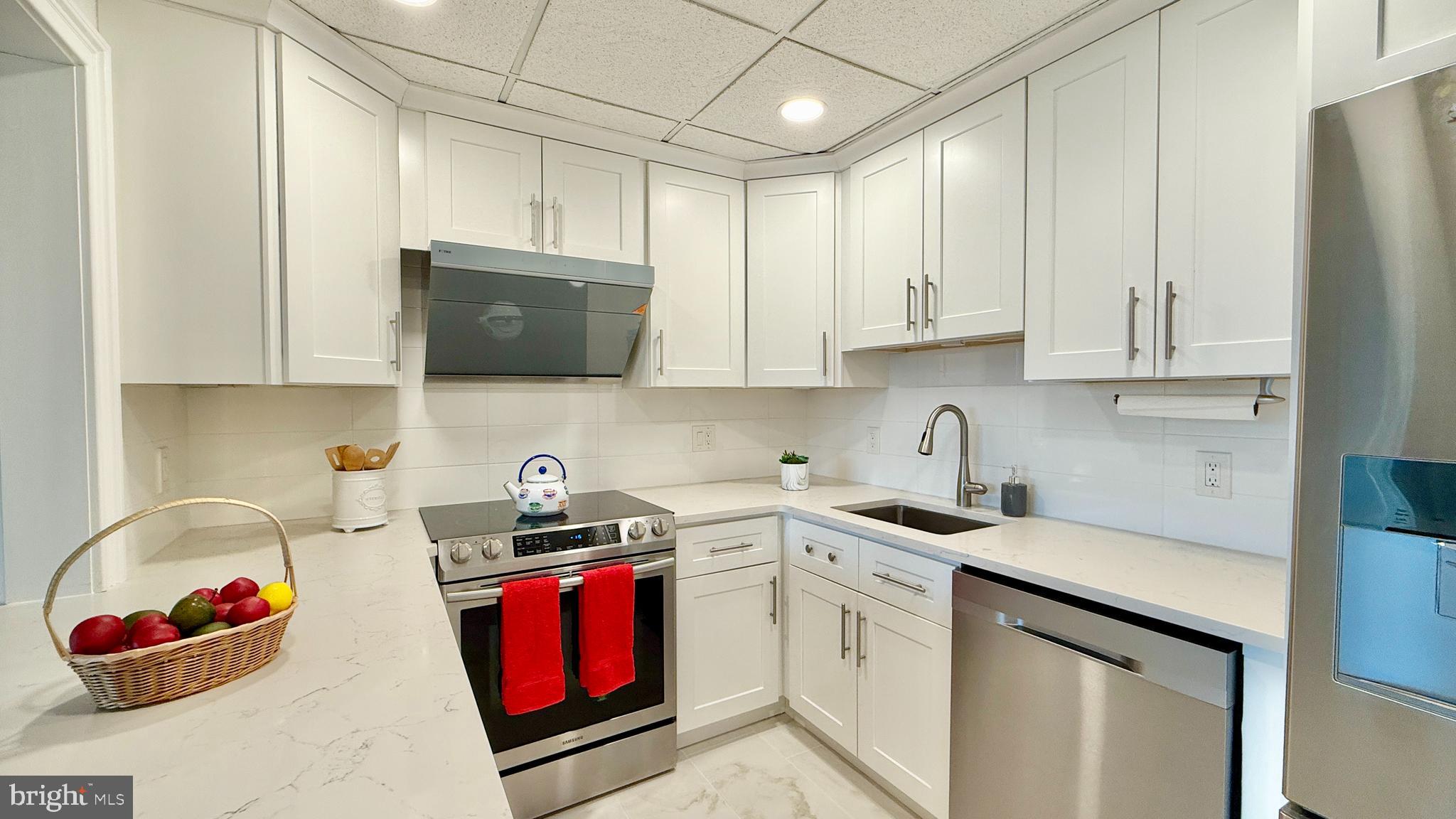 1 Markham Road, Unit 2E Princeton, NJ 08540 - Photo 20 of 30 a kitchen with stainless steel appliances granite countertop a sink stove refrigerator and cabinets
