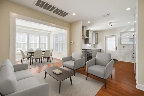 a living room with furniture and a large window with wooden floor