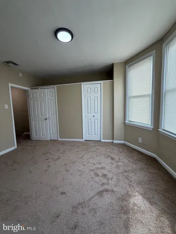 an empty room with windows and closet