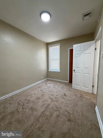 an empty room with windows and closet