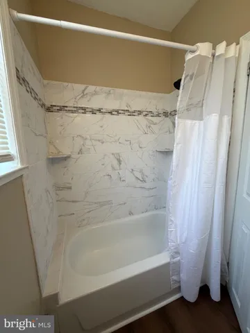 a bathroom with a shower and a bath tub