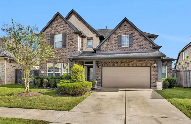 a front view of a house with a garden and plants