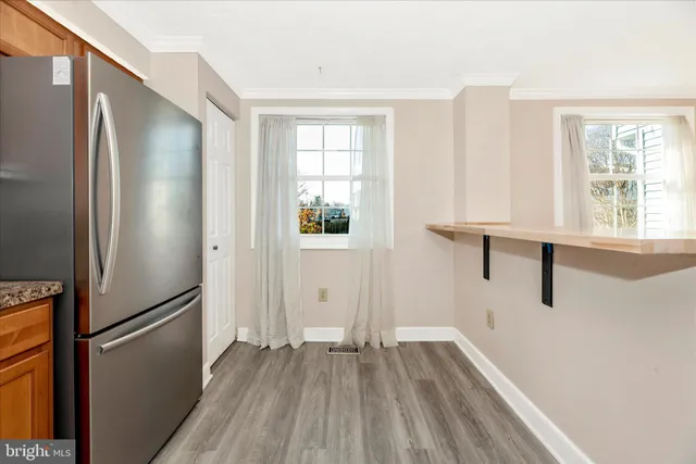 a view of empty room with wooden floor and window