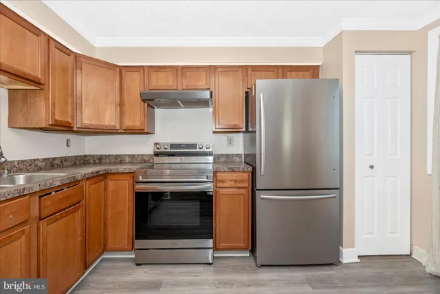 a kitchen with a refrigerator sink and cabinets