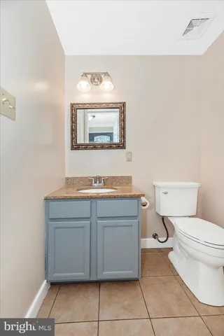 a bathroom with a toilet sink vanity and mirror