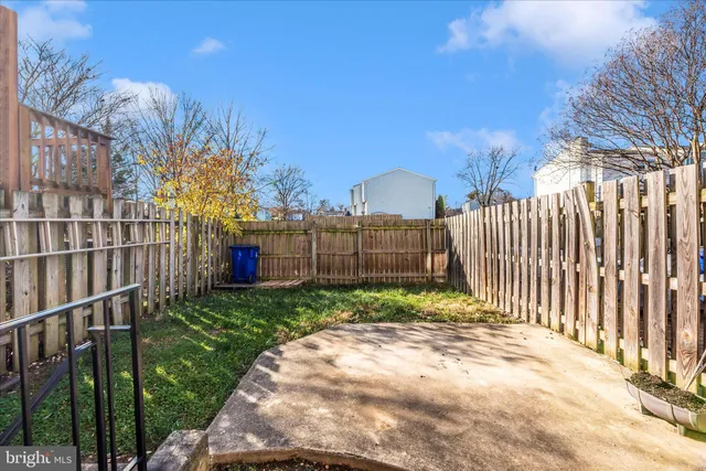 a view of a backyard with wooden fence