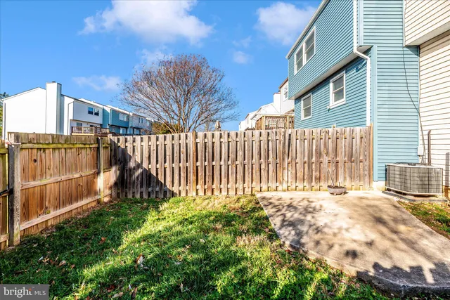 a view of a house with a small yard and wooden fence