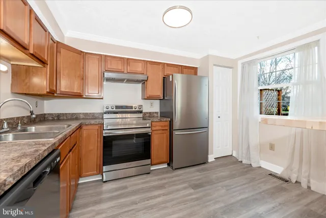 a kitchen with granite countertop a refrigerator stove and sink