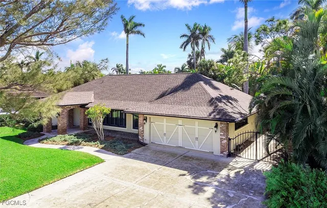 a view of a house with a yard and potted plants