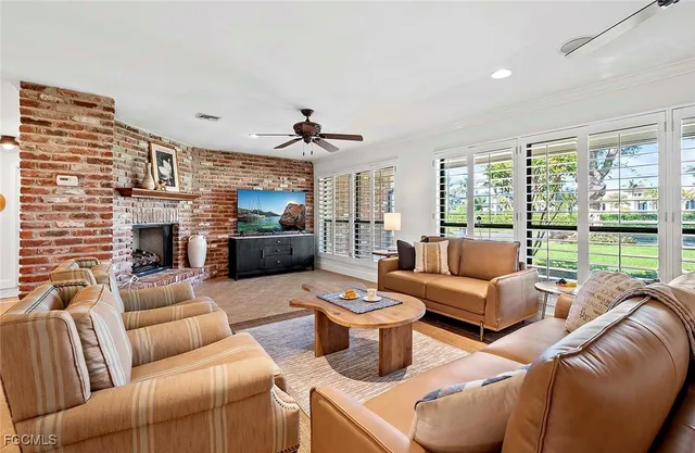 a living room with furniture a fireplace and a flat screen tv