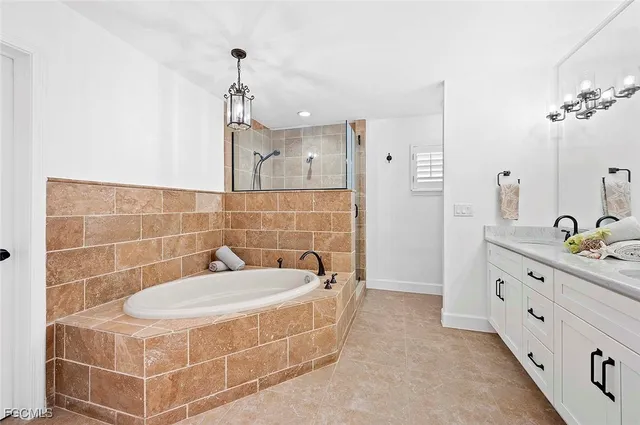 a bathroom with a tub sink and mirror