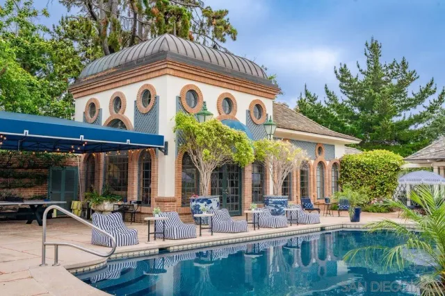a front view of a house with garden and trees