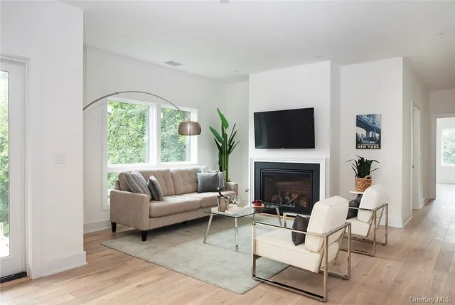 a living room with furniture a fireplace and a large window