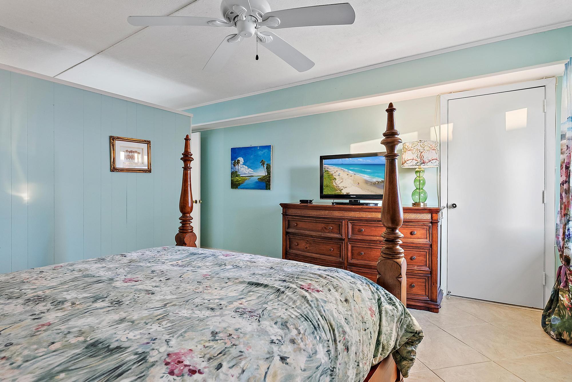 1561 Northeast 12th Terrace, Unit C14 Jensen Beach, FL 34957 - Photo 11 of 38 a bedroom with a bed and a flat screen tv