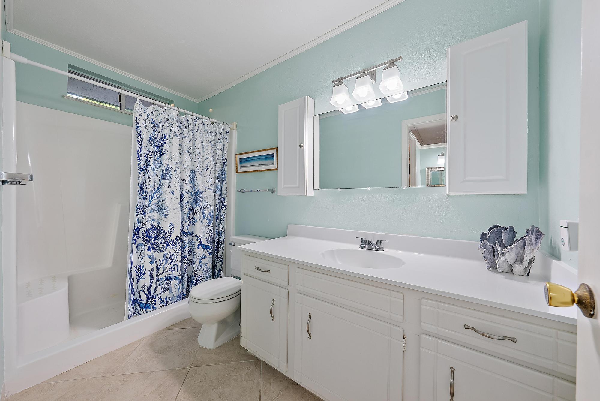 1561 Northeast 12th Terrace, Unit C14 Jensen Beach, FL 34957 - Photo 12 of 38 a bathroom with a sink a toilet and a mirror