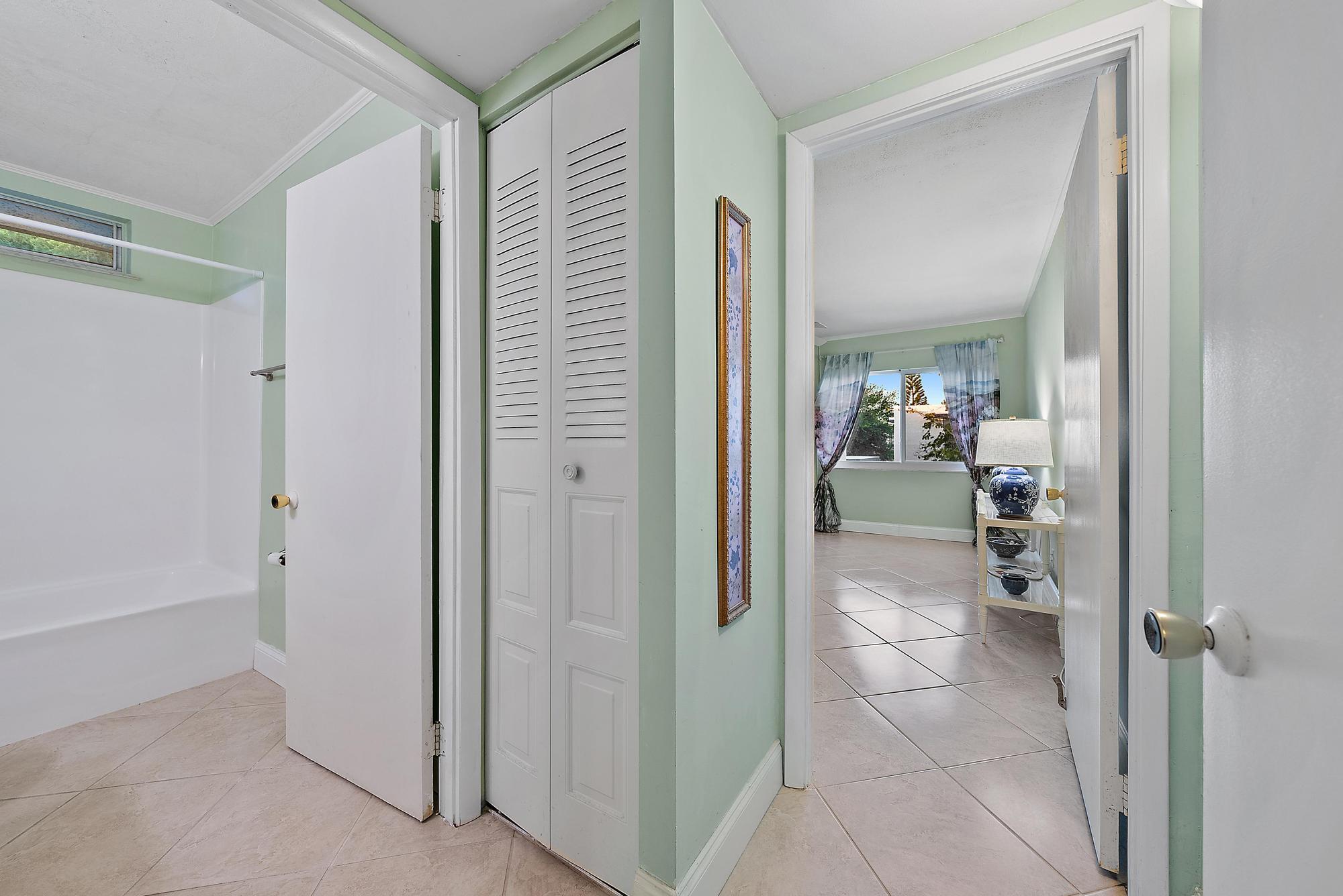 1561 Northeast 12th Terrace, Unit C14 Jensen Beach, FL 34957 - Photo 15 of 38 a bathroom with a glass door shower a mirror and a sink