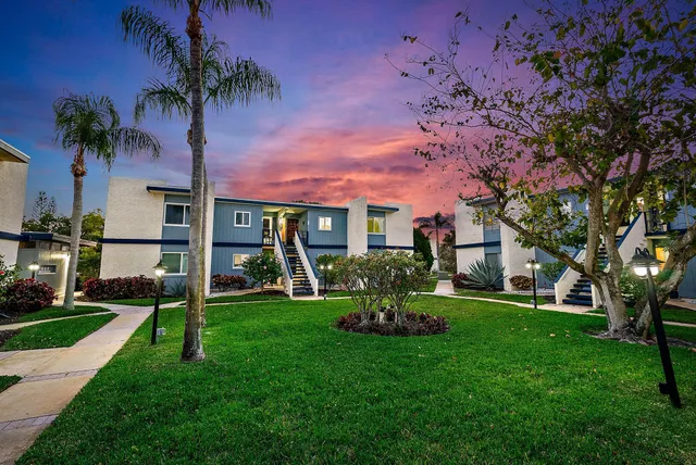 a front view of a house with garden and trees