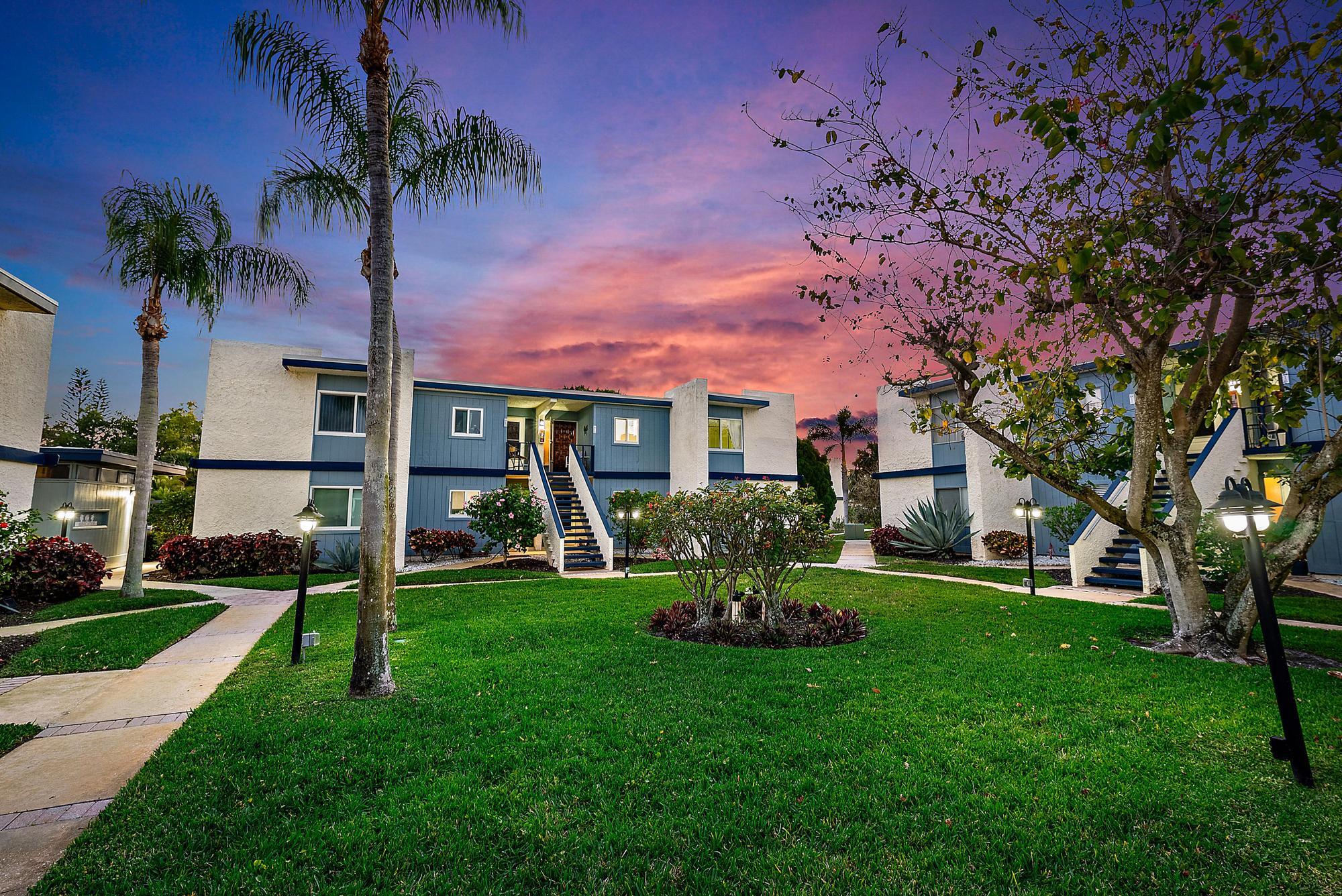 1561 Northeast 12th Terrace, Unit C14 Jensen Beach, FL 34957 - Photo 21 of 38 a front view of a house with garden and trees