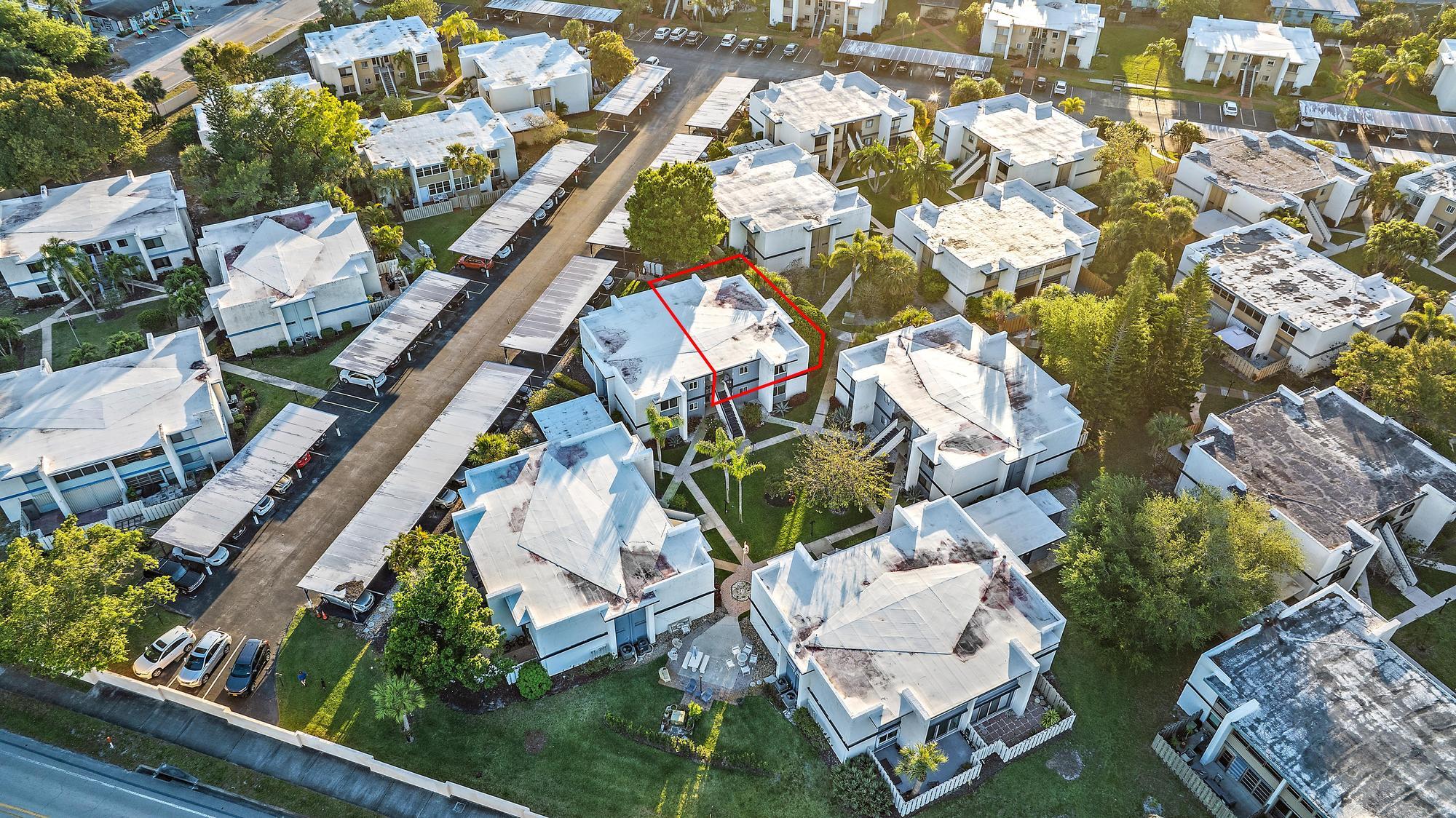 1561 Northeast 12th Terrace, Unit C14 Jensen Beach, FL 34957 - Photo 29 of 38 an aerial view of a house with a yard and lake view