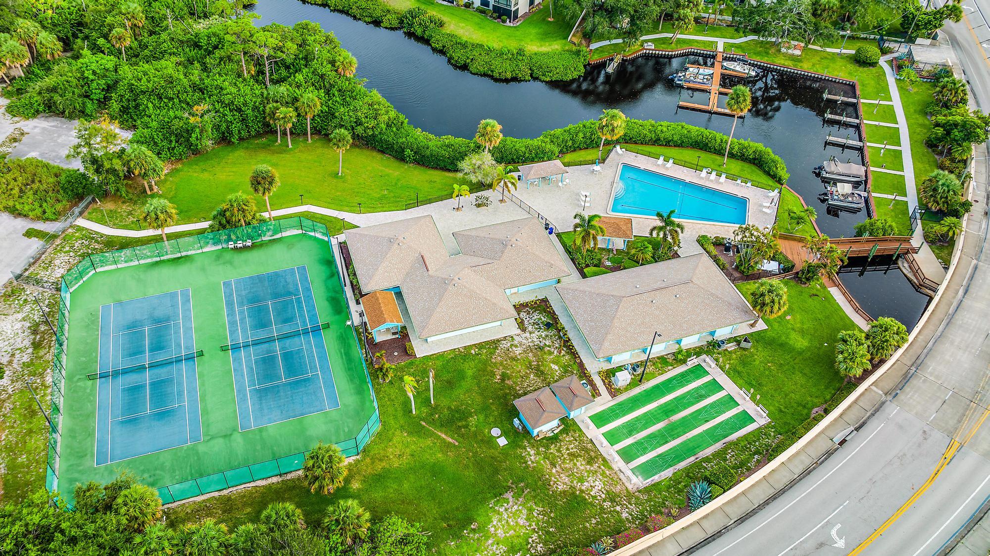 1561 Northeast 12th Terrace, Unit C14 Jensen Beach, FL 34957 - Photo 32 of 38 an aerial view of a house with a garden and trees