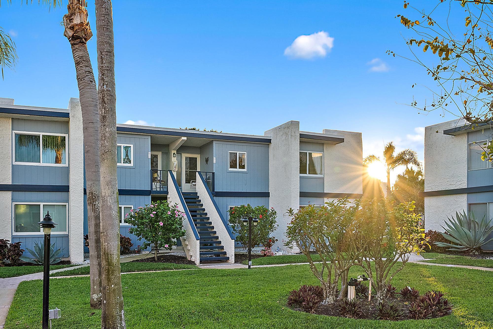 1561 Northeast 12th Terrace, Unit C14 Jensen Beach, FL 34957 - Photo 4 of 38 a front view of a house with a yard