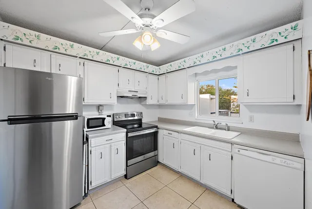 a kitchen with cabinets stainless steel appliances and a window