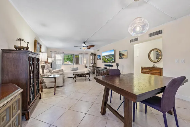 a view of a dining room and livingroom view with furniture a rug and a clock