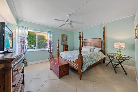 a bedroom with a bed and a flat tv screen on the dresser